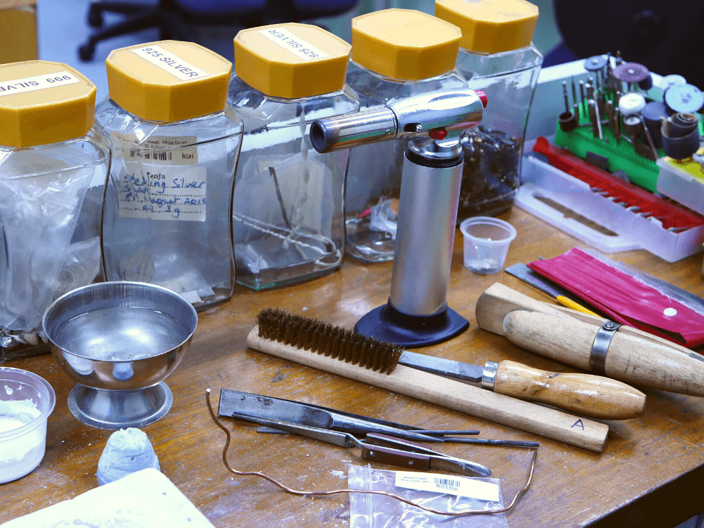 Metal arts tools and materials displayed on a bench